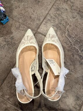 A New Day cream lace slingback kitten heels with a pointed toe and bow detail.